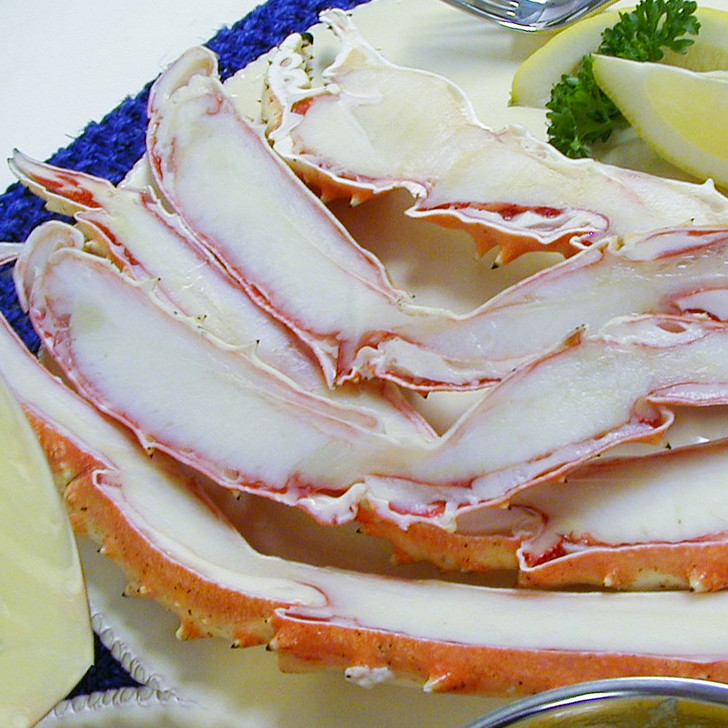 Split king crab legs on a white plate.