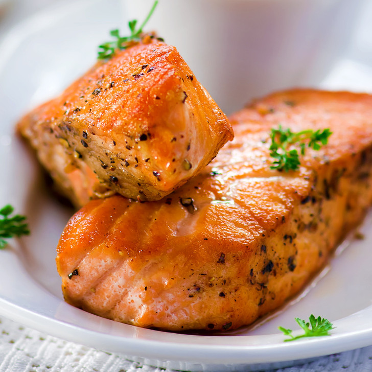 Two Copper River sockeye salmon fillet portions resting in a white oval platter.