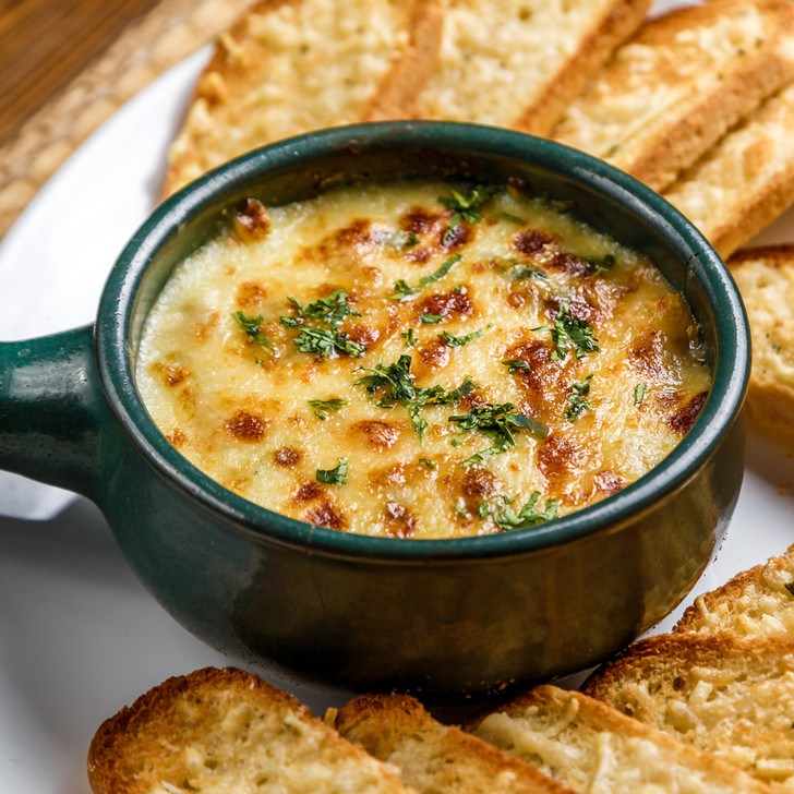 Bubbly cheesy crab & artichoke dip surrounded by toasted cheese bread.