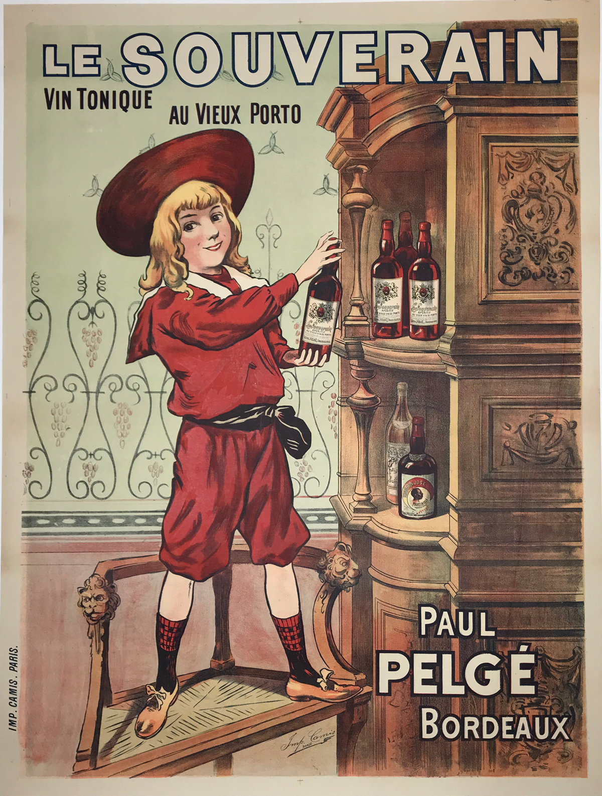 Le Souverain by Imp. Camis 1910 France. French wine and spirits poster features a child in a red suit and hat standing on a chair getting a bottle off the top shelf. Original Antique Posters.