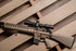 Tan PRI Mark 12 Mod 0 Gen III rifle mounted with Nightforce Optics NX6 2-12x42mm F1 on tan 1.54 Ultramount, laying on a pallet (C730, C729).