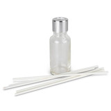 A glass scented diffuser bottle with a silver lid and five white reeds arranged beside it.