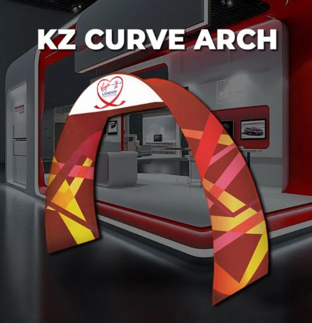 A double-sided, curved fabric arch in vibrant red and yellow patterns, featuring a logo on top.