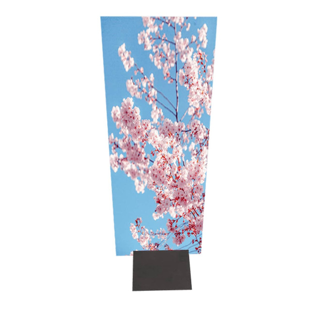 A signage stand featuring a vibrant image of pink cherry blossoms against a blue sky, supported by a black metal base.