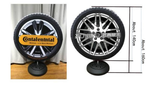 A round promotional display featuring a tyre design, with a black base and branded artwork on the front.