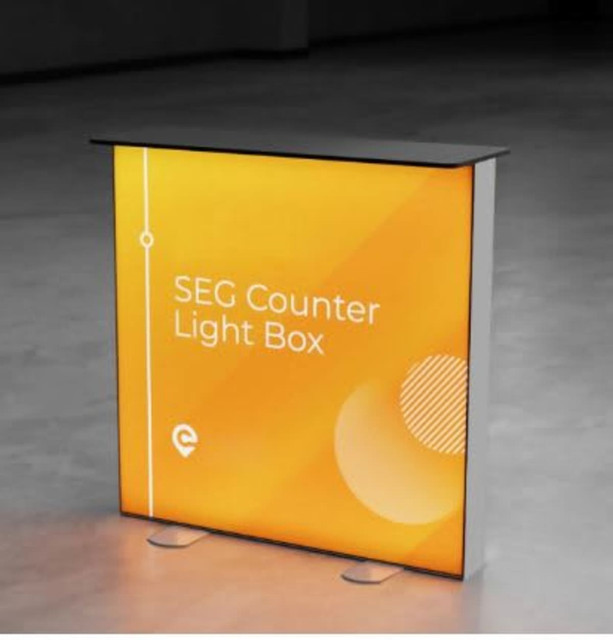 A promotional light box table with an aluminium frame, featuring an orange backdrop and a black top.