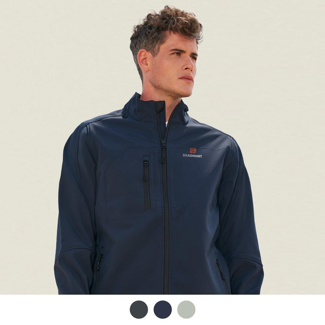 A man wearing a navy softshell jacket features zippered pockets and has a logo on the chest.