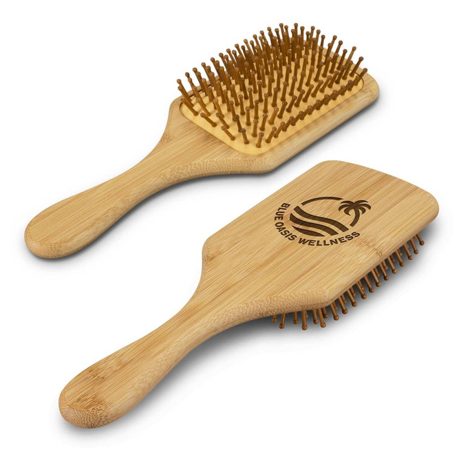 A bamboo hair brush with a flat design, featuring golden bristles and a logo on one side.
