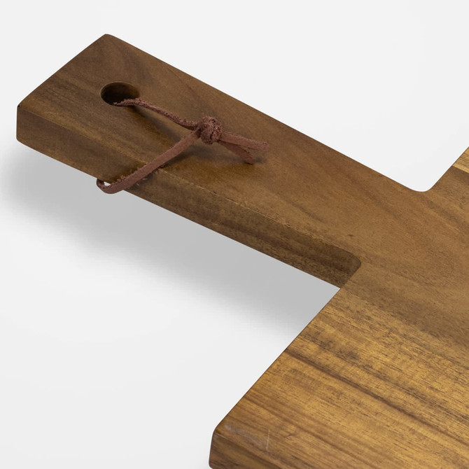 A wooden chopping board with a natural finish and a leather tie attached for hanging.