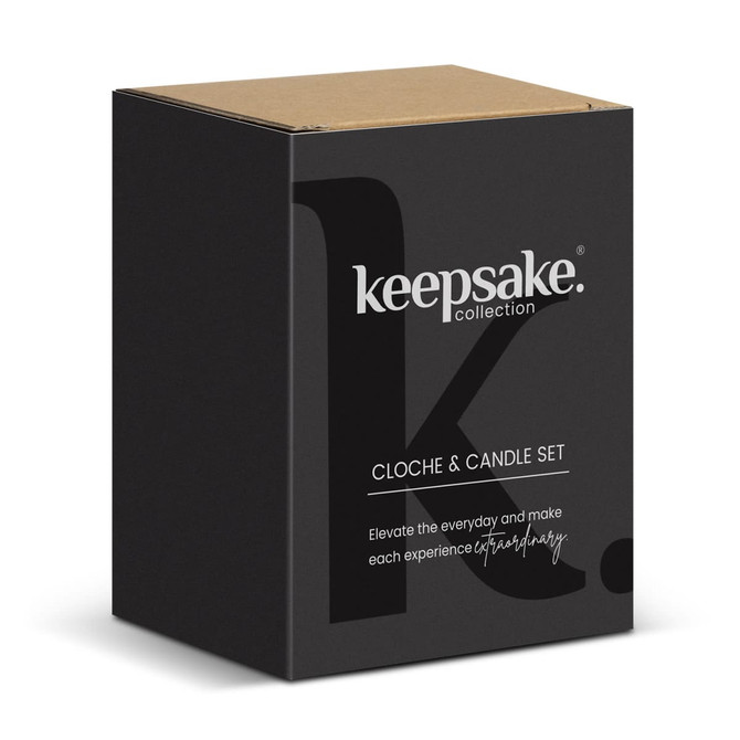 A black box with a cardboard lid containing a cloche and candle set, featuring a logo on the front.