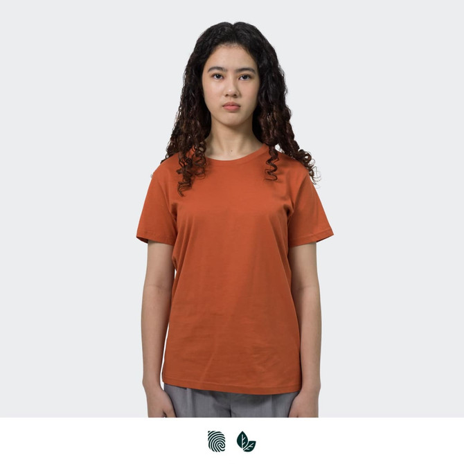 An orange women's T-shirt displayed on a model, featuring a simple design and a logo.