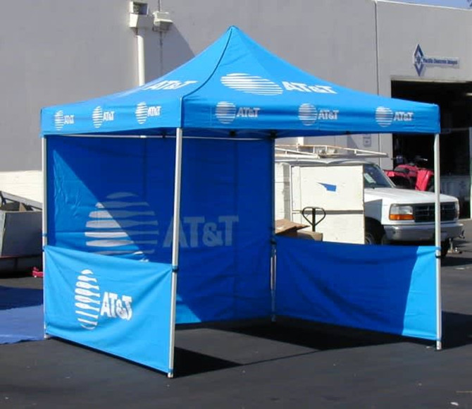 A blue promotional tent with walls and a peaked roof, featuring branding logos.