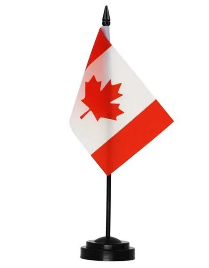 A small Canadian flag with a red and white design, mounted on a black stand.