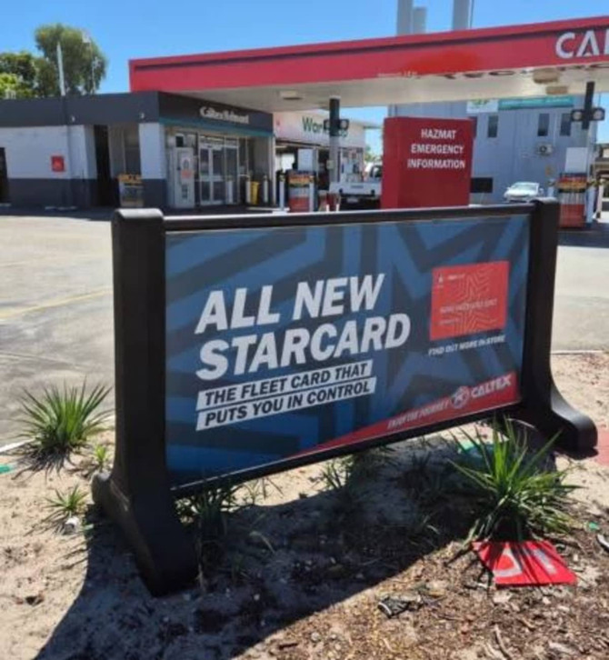 A signage barrier in black with a vibrant blue and red promotional display, featuring a branding logo.