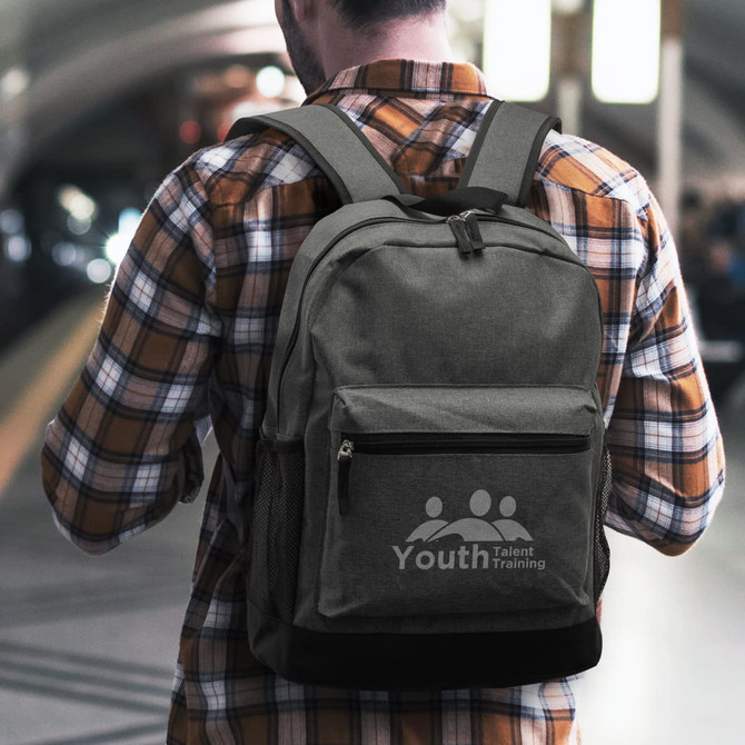A grey backpack with a front pocket and side mesh pockets is worn by a person in a checkered shirt.