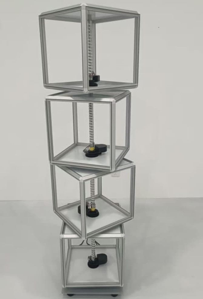 A rotating light box with transparent compartments, featuring a silver frame and black bases, designed for exhibitions and events.