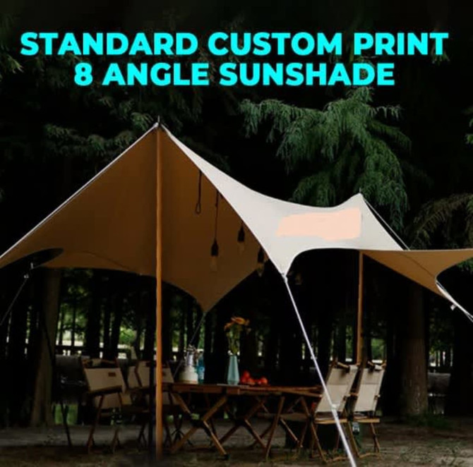 A tan canopy with eight angles set up outdoors among trees, featuring poles and hanging lights.
