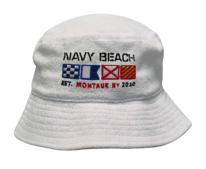 A white terry towelling bucket hat featuring an embroidered design with nautical symbols and the text "Navy Beach".