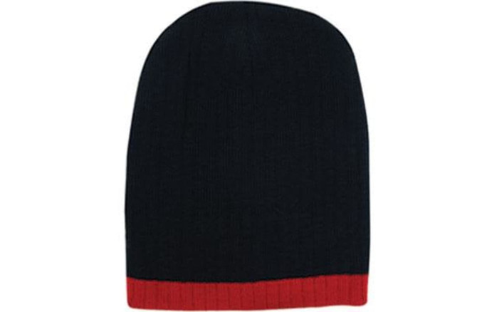 A two-tone cable knit beanie in navy blue with a red ribbed band at the bottom. It features a logo.