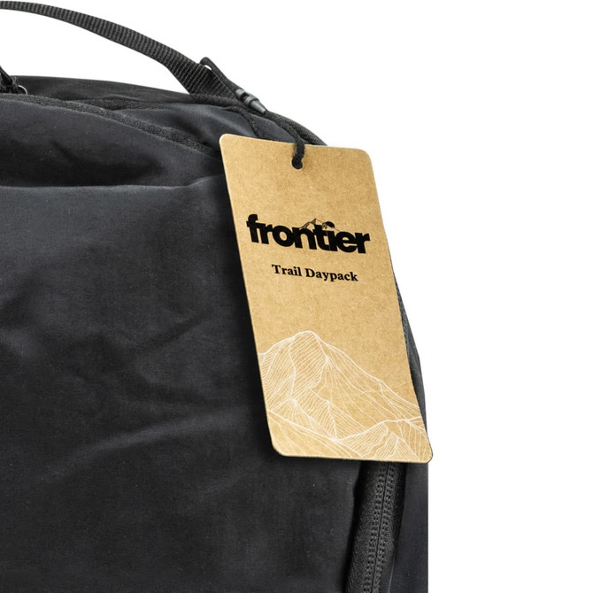 A black daypack with a tag attached, featuring a simple mountain graphic and a logo.