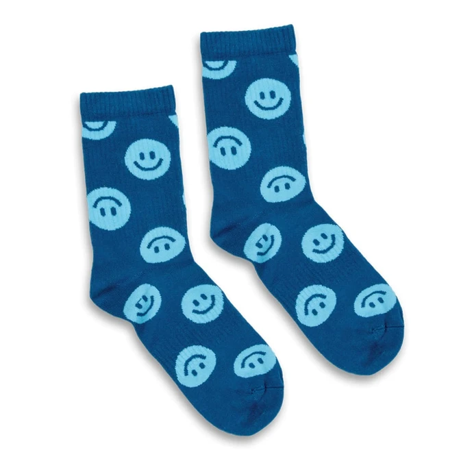 A pair of blue crew socks featuring light blue smiley face patterns. The socks have a logo on one side.