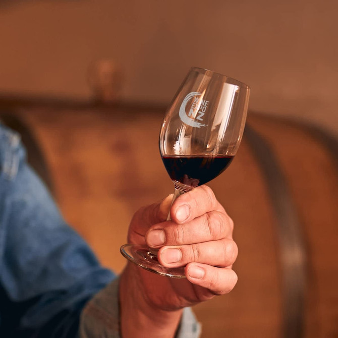 A wine glass with a curved bowl and stem, containing red wine, featuring a logo on its surface.