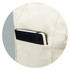 A cream canvas tote bag with a black notebook tucked into a side pocket. The bag features a logo.