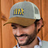 A grey and tan corduroy peak cap with a logo on the front, featuring a mesh back.