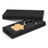 A house-shaped key ring in a black presentation box, featuring a wooden front and metal ring.