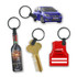 A collection of four key rings, including a car, a wine bottle, a key, and a red vest, all on black rings.