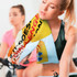A full-colour sports towel draped over a woman's shoulder, featuring vibrant graphics, with a blurred background of individuals at a gym.
