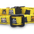 A yellow cat collar featuring various cartoon cats in shades of grey, black, and orange with a black buckle.