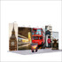 A tension fabric display booth featuring urban landmarks, including a red bus, clock tower, and various city scenes.