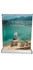 A table top pull-up banner featuring a scenic view of a boat by a turquoise sea, with mountains in the background.