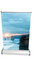 A table top pull-up banner featuring a scenic coastal image with a sunset, in shades of blue and orange. It has a logo.