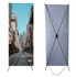 An X banner featuring a city street scene, set against a light blue background with a sturdy black frame.