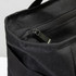 A black cooler bag with a zip closure and textured fabric, featuring an exterior pocket.