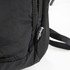 A black daypack with mesh detailing and a logo on the side. The straps are partially visible.