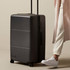 A large black suitcase on wheels with a retractable handle and a logo.