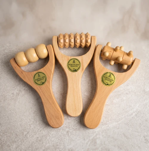Three wooden hand massage rollers in bead, diamond ridge, and knob styles with Northland Remedies logo stickers