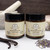 Northland Remedies Lotions in a 4 oz amber glass jar, displayed next to an open jar of thick white topical cream, vanilla beans, lavender buds, and a white ceramic mortar and pestle on a dark wood background.
