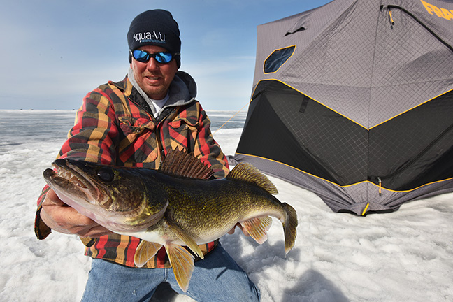 fisherman holding very big walleye caught with the slender spoon