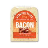 A vacuum-sealed block of Yancey's Fancy "Bacon" New York Cheddar cheese. The arched label features a color scheme of bright orange at the top that gradients into a lighter peach color in the middle, and finishes with a solid red section at the bottom. The central illustration shows a pile of wavy, crispy cooked bacon strips. Faint line drawings of small cartoon pigs decorate the peach-colored background.

The text at the top reads "Yancey's Fancy" arched above the tagline "Simple Ingredients. Bold Flavor." The product name "BACON" is written in large, bold white capital letters. The red bottom section reads "New York Cheddar Pasteurized Process" with a net weight of 7.6 oz (215 g). Small, dark reddish-brown flecks of bacon are scattered throughout the creamy, off-white cheese block.