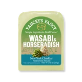 A vacuum-sealed block of Yancey's Fancy "Wasabi & Horseradish" New York Cheddar cheese. The arched label features a color palette that transitions from a vibrant grass green at the top to a light tan in the middle, and finishes with a teal blue section at the bottom. The central illustration features a small swirl of bright green grated wasabi paste next to a dollop of white, textured grated horseradish. The tan background section includes faint line drawings of sushi rolls, chopsticks, and horses.

The text at the top reads "Yancey's Fancy" arched above the tagline "Simple Ingredients. Bold Flavor." The product name "WASABI & HORSERADISH" is written in large, bold white capital letters. The teal bottom section reads "New York Cheddar Pasteurized Process" with a net weight of 7.6 oz (215 g). The block of cheese itself has a distinct, uniform light-green hue.