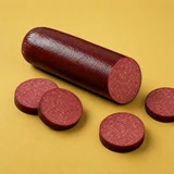 Yancey's Fancy Beef Summer Sausage sliced with a yellow background.