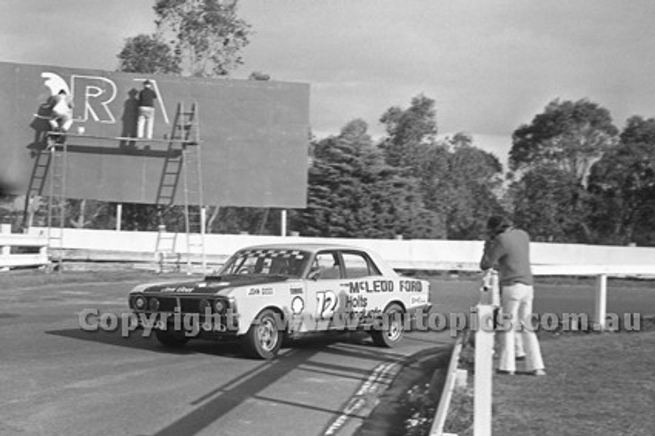 72264 - John Goss  Ford Falcon GTHO Phase 3 - Check out the sign writers ladders, they are on the track side of the fence during practice at Sandown 9th September 1972  - Photographer Peter D'Abbs