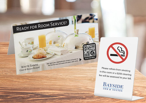 Custom printed plastic table tents displayed on restaurant table — full color PVC table top signs with QR code for menus and promotions, hotels and dining use, made in USA
