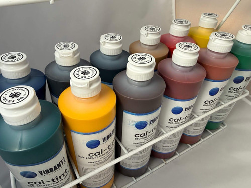 Metal rack with 12 cal-tint color bottles inside of it from an angle above