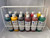 Metal rack with 12 cal-tint color bottles inside of it from straight on with a slight angle down