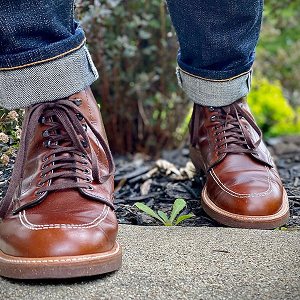 Brown leather Alden boots on a garden path.